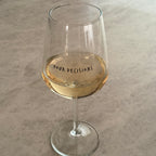 Pour Decisions wine glass filled with white wine, side view showing text and stem detail