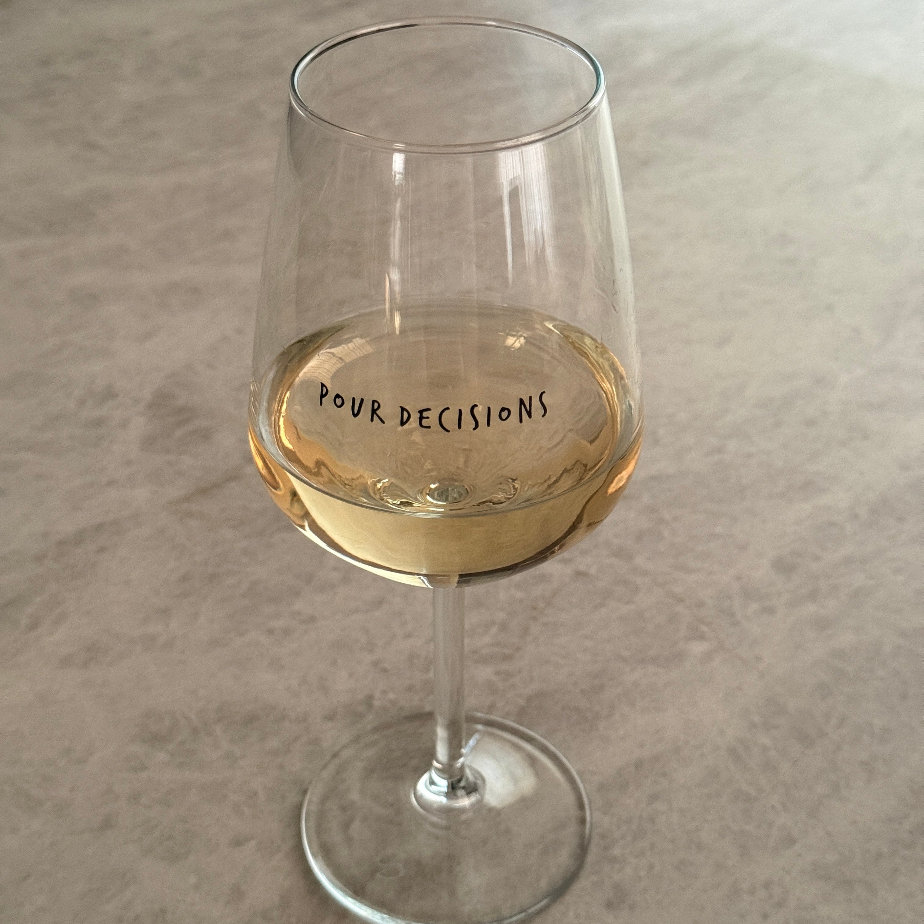 Pour Decisions wine glass filled with white wine, side view showing text and stem detail