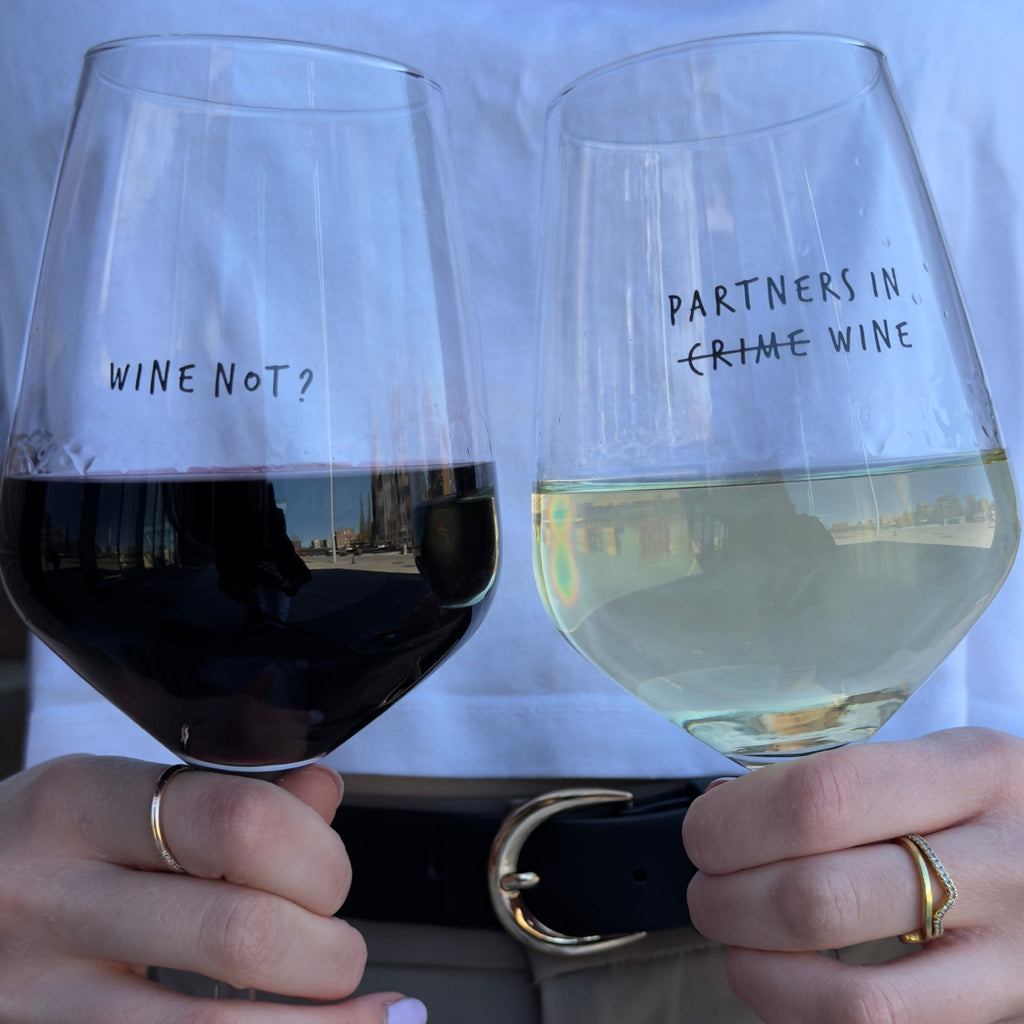 Partners in Wine and Wine Not glasses side by side, filled with red and white wine