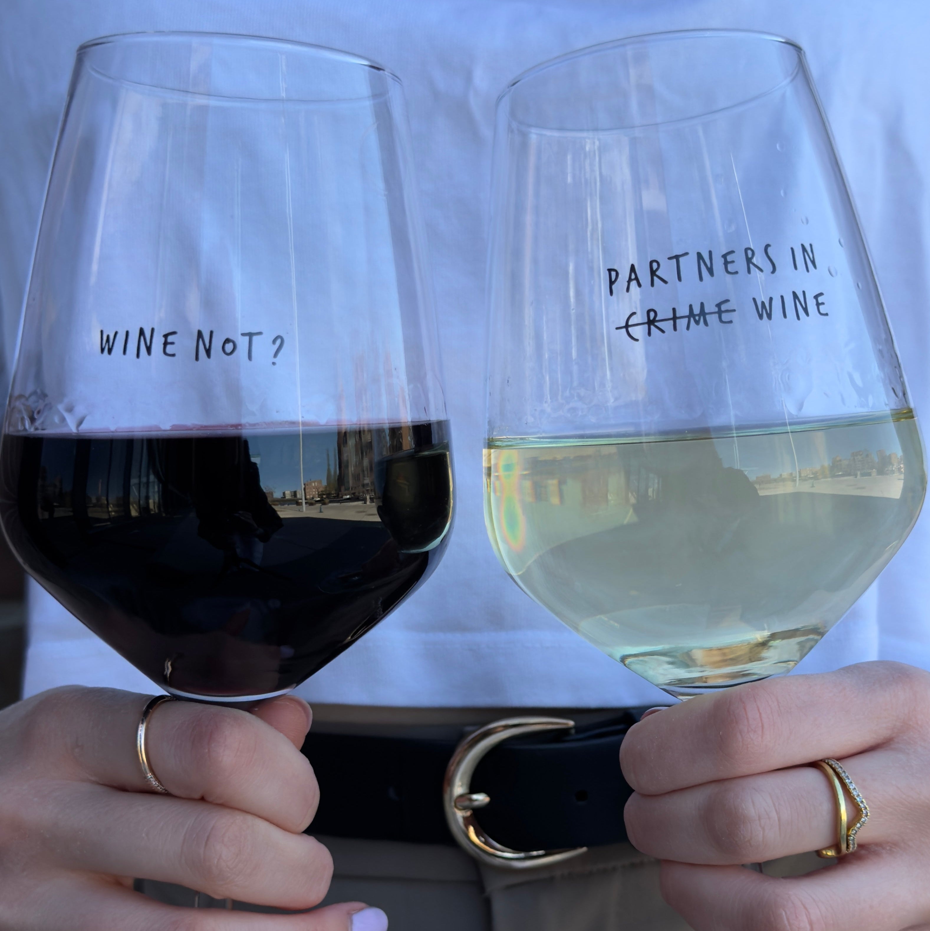 Partners in Wine and Wine Not glasses side by side, filled with red and white wine